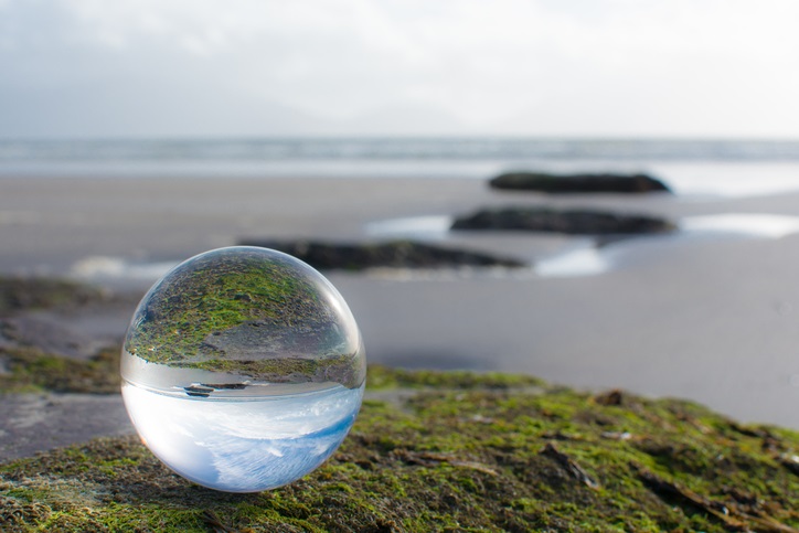 A water droplet sitting next to a beach
