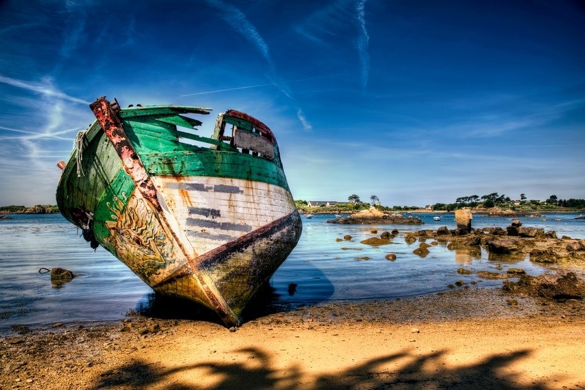 A destroyed boat sitting on the beach